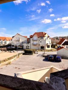 - une vue sur un parking avec quelques bâtiments dans l'établissement COC - Le Panorama, à Wissant