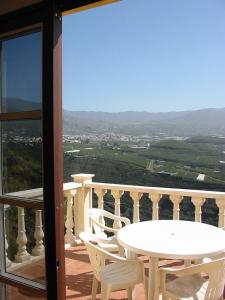 Biały stół i krzesła na balkonie z widokiem w obiekcie Casa Time w mieście Tijarafe