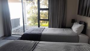 a bedroom with two beds and a large window at Oribi Gorge Villa in Glendale