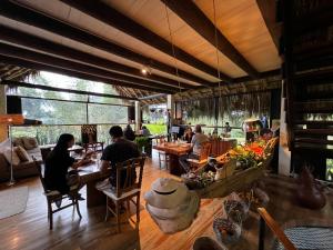 a group of people sitting at tables in a restaurant at Lodges Boutique La Nuit in La Vega