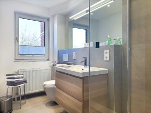 bagno con lavandino e servizi igienici di W1 - Gästehaus Christian-Westphal-Str 60 - FERIENDOMIZIL HOLLICH a Grömitz