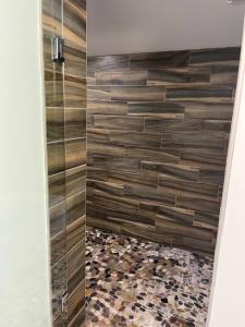 a bathroom with a shower with wooden tiles at Luxury 2BR within walking distance to Nightlife!! in Covington