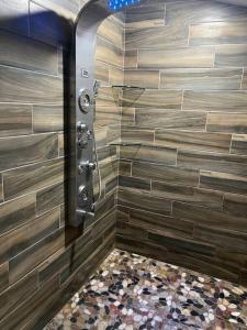 a shower in a bathroom with a stone wall at Luxury 2BR within walking distance to Nightlife!! in Covington