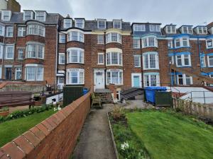 a large brick building with a yard in front of it at Sea View flat 2 with Fast WiFi and FREE parking in Scarborough