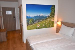 a bedroom with a bed with a painting on the wall at Sporthotel Zederhaus im Lungau in Zederhaus