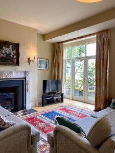 a living room with a fireplace and a tv at The Coach House at Moyglare Manor in Maynooth
