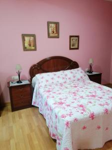 a bedroom with a bed with a pink wall at NIDO in Ribadeo