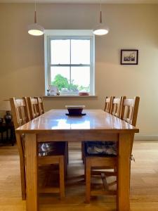 mesa de comedor con sillas y ventana en The Coach House at Moyglare Manor, en Maynooth
