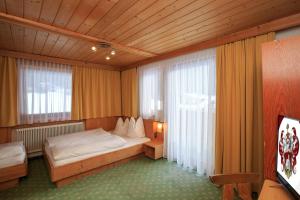 ein Schlafzimmer mit einem Bett und einem großen Fenster in der Unterkunft Apartments Seerhof in Kaunertal