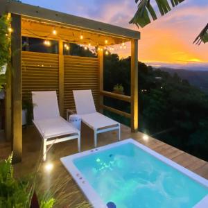 a hot tub on a patio with two chairs and a sunset at Villa Vacacional en Puerto Rico para parejas in Villalba