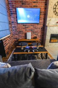 een woonkamer met een tv aan een bakstenen muur bij Da Vinci Apartment in Vratsa