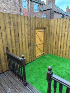 a wooden fence with a gate with a door at Watford Road House Liverpool in Liverpool