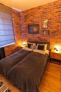 a bedroom with a large bed in a brick wall at Da Vinci Apartment in Vratsa