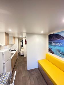a kitchen and a living room with a yellow couch at Camping Village La Sorgente in Portoferraio