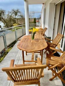 a wooden table and chairs on a balcony with yellow flowers at Dream Flat near the fair - Apartment in Augsburg bei der Messe in Augsburg