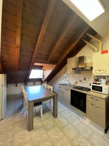 eine Küche mit einem Holztisch und einer Holzdecke in der Unterkunft Affittacamere Karma in Rho