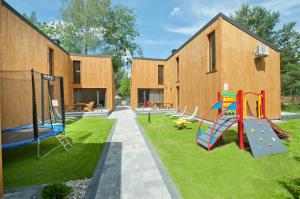 a building with a playground in the yard at Kapitanka Apartamenty in Okuninka