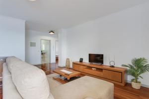 a living room with a couch and a tv at Santa Cruz Apartment with Sea View by HR Madeira in Santa Cruz