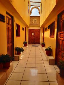 an empty hallway with potted plants in a building at HOTEL CAMELINAS AREA BLANCA in Pátzcuaro