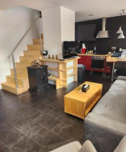 a living room with a couch and a table and a kitchen at Duplex cosy Life Balnéo in Cysoing