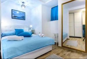 ein Schlafzimmer mit einem blauen Bett und einem Spiegel in der Unterkunft Apartman Gloria in Dubrovnik
