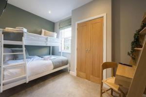 a bedroom with two bunk beds and a desk at Lettered Board Apartments 1, 2 & 3 in Pickering
