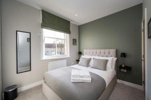 ピカリングにあるLettered Board Apartments 1, 2 & 3の大きなベッドとタオル2枚のある寝室