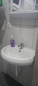 - un lavabo blanc avec une boîte de savon violet dans l'établissement Apartman Cirkic, à Sanski most