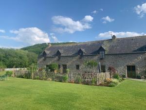 een stenen huis met een hek in een tuin bij La Bergerie - Gîte et Chambres d'Hôtes in Roz-sur-Couesnon