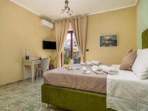 Schlafzimmer mit einem Bett, einem Schreibtisch und einem Fenster in der Unterkunft La Rosa Home Sorrento coast in Piano di Sorrento
