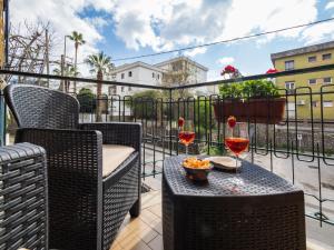 einen Balkon mit einem Tisch und 2 Gläsern Wein in der Unterkunft La Rosa Home Sorrento coast in Piano di Sorrento