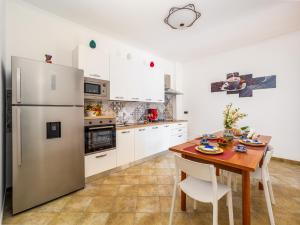 eine Küche mit einem Holztisch und einem Kühlschrank in der Unterkunft La Rosa Home Sorrento coast in Piano di Sorrento