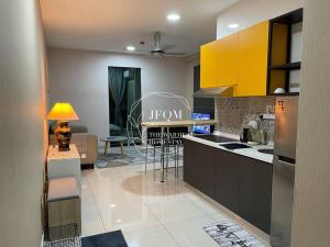 a kitchen with yellow cabinets and a living room at Liberty ARC - Greenary & Warmest (Wifi) (2-3pax) in Ampang