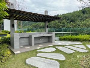 un patio de piedra con un banco en un jardín en Liberty ARC - Greenary & Warmest (Wifi) (2-3pax) en Ampang