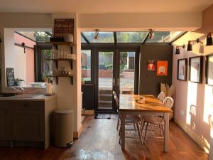 a kitchen with a wooden table and a dining room at Margate Escape House, sleeps 5-6. Free parking. in Kent