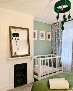 a baby room with a crib and a mirror at Margate Escape House, sleeps 5-6. Free parking. in Kent