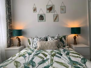 a bedroom with a bed with a green and white comforter at Margate Escape House, sleeps 5-6. Free parking. in Kent