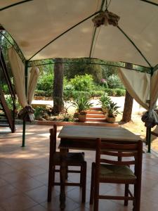 a table and chairs under a tent with plants at Villa Rosemary in Marsala