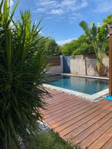 una piscina en una terraza de madera con plantas en Villa HIMANI en Saint-Gilles-les-Bains