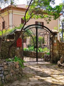 una puerta de hierro que da a un jardín frente a un edificio en Aragonite Azzurra Casa Vacanza, en Gonnesa