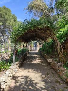 um arco sobre um caminho num jardim em Aragonite Azzurra Casa Vacanza em Gonnesa