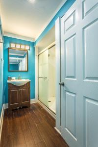 a bathroom with a white sink and a door at St George Inn in St. George Island