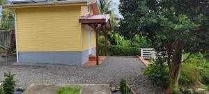 ein gelbes Haus mit einem Weg neben einem Garten in der Unterkunft PITAYA in Ducos