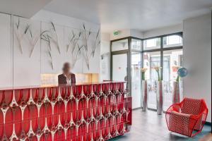 a woman sitting at a counter in a restaurant at Hotel Joyce - Astotel in Paris