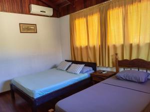 Zimmer mit 2 Betten und einem Fenster in der Unterkunft Condominio Villa Hermosa in Playa Hermosa