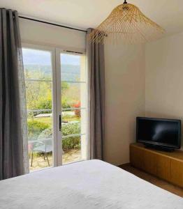 a bedroom with a bed and a tv and a window at Splendide villa 10p./4 suites/piscine/clim/paysage in Bargemon