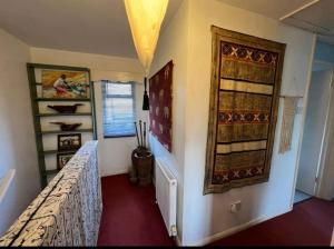 a bedroom with a bed and a wall with a window at Cosy private accommodation in Corsham, near Bath in Corsham