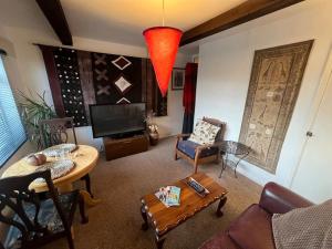 a living room with a table and a tv at Cosy private accommodation in Corsham, near Bath in Corsham