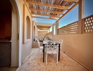 a dining room with a table and chairs on a balcony at Dar diafa samira in Mirleft