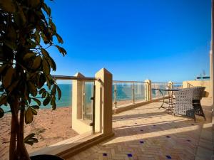 a deck with a table and chairs on the beach at Dar diafa samira in Mirleft